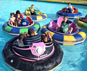 four brightly colored bumper boats filled with riders at Celebration Station amusement park in Clearwater, Florida -- one of many family-friendly things to do in Clearwater Beach.