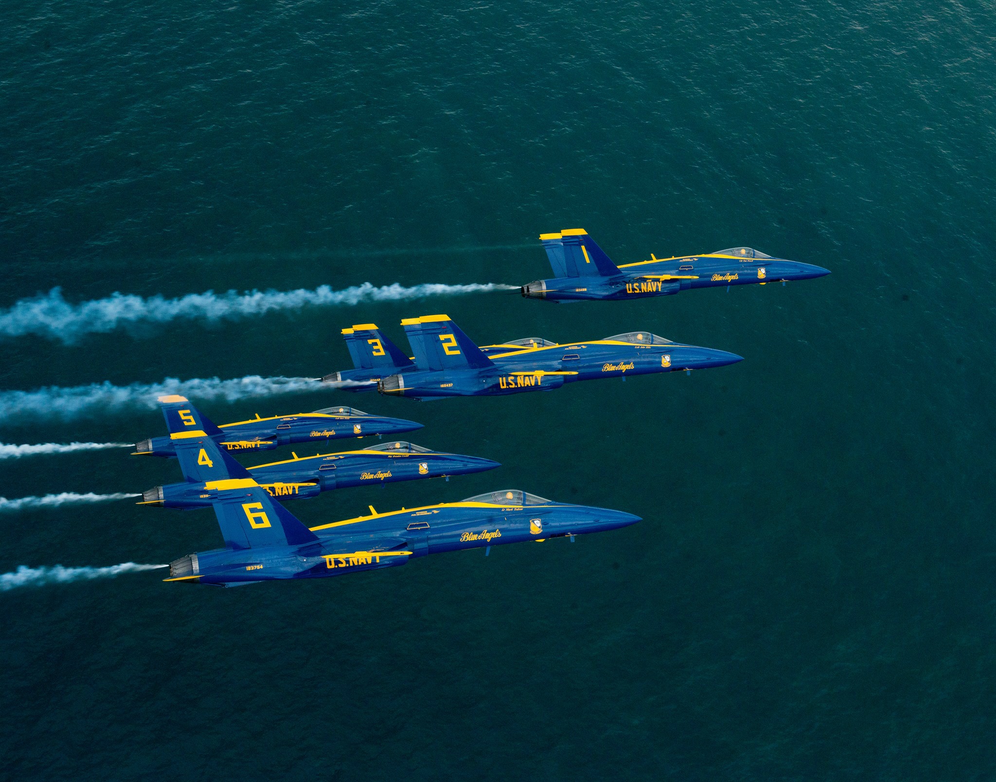 Six Blue Angels jets fly in formation over the Gulf of Mexico in Pensacola Beach FL.
