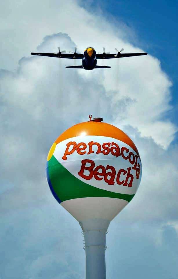 Fat Albert, the cargo plane that carries all of the Blue Angels’ show equipment, flies over the beach ball water tower at Pensacola Beach on its way to the Blue Angels Homecoming Air Show.