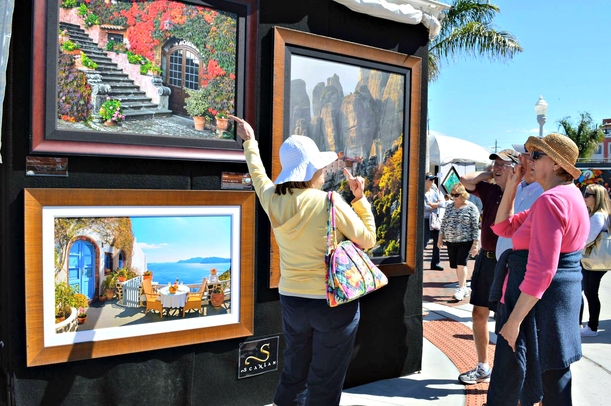 A pair of women shoppers survey an outdoor art display during ArtFest Fort Myers.