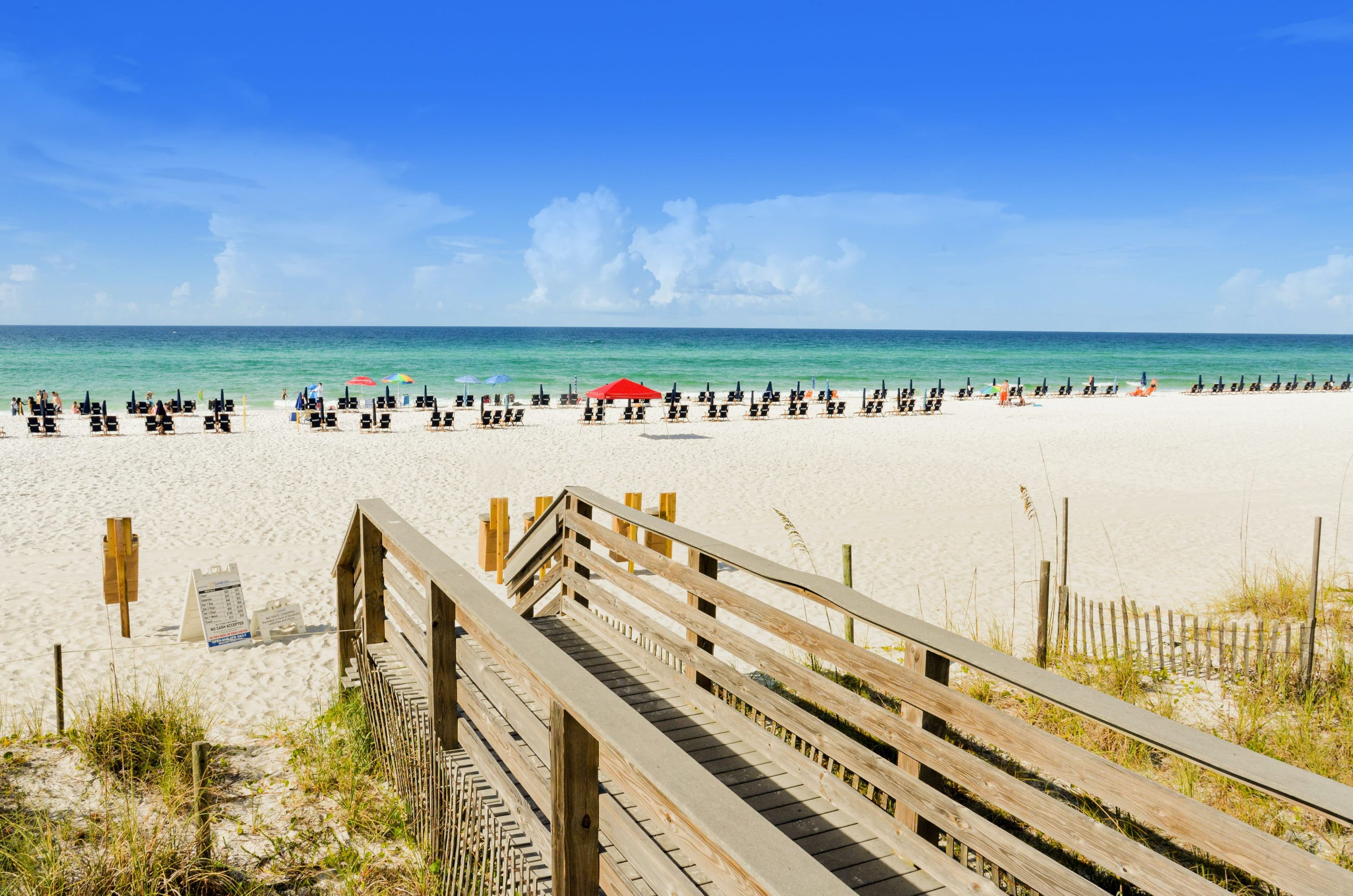 A beach boardwalk leads directly to the white sand beach and turquoise blue Gulf waters near Sandestin Golf and Beach Resort's Luau complex