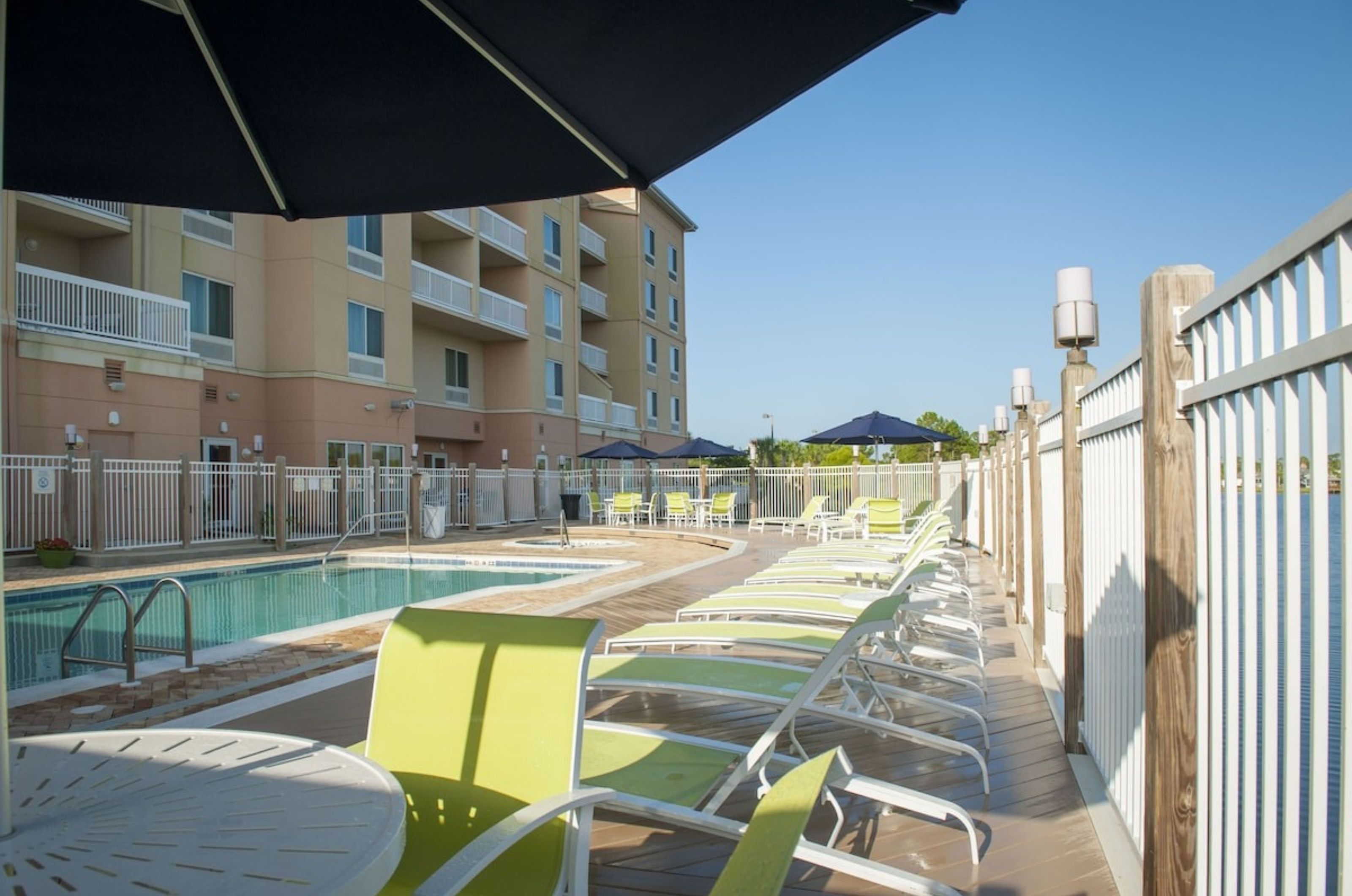 Pool chairs and umbrellas next to the outdoor pool at Fairfield Inn and Suites 