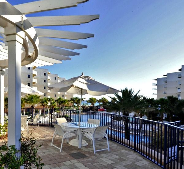 Patio with covered seating overlooking the pool area at Waterscape Resort in Fort Walton Beach