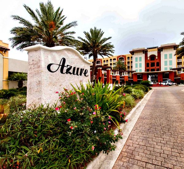 Tropical landscaping surrounds the street-side sign at Azure Fort Walton Beach.