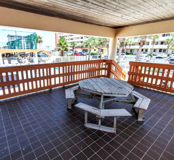Interior of covered picnic area with table and benches at Surf Dweller Fort Walton Beach
