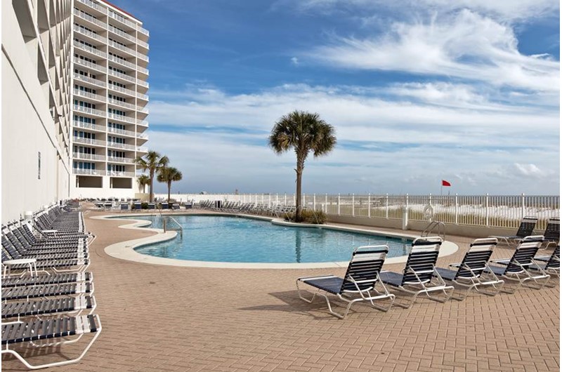 Comfortable lounge chairs flank the beachfront pool at the Lighthouse Gulf Shores.
