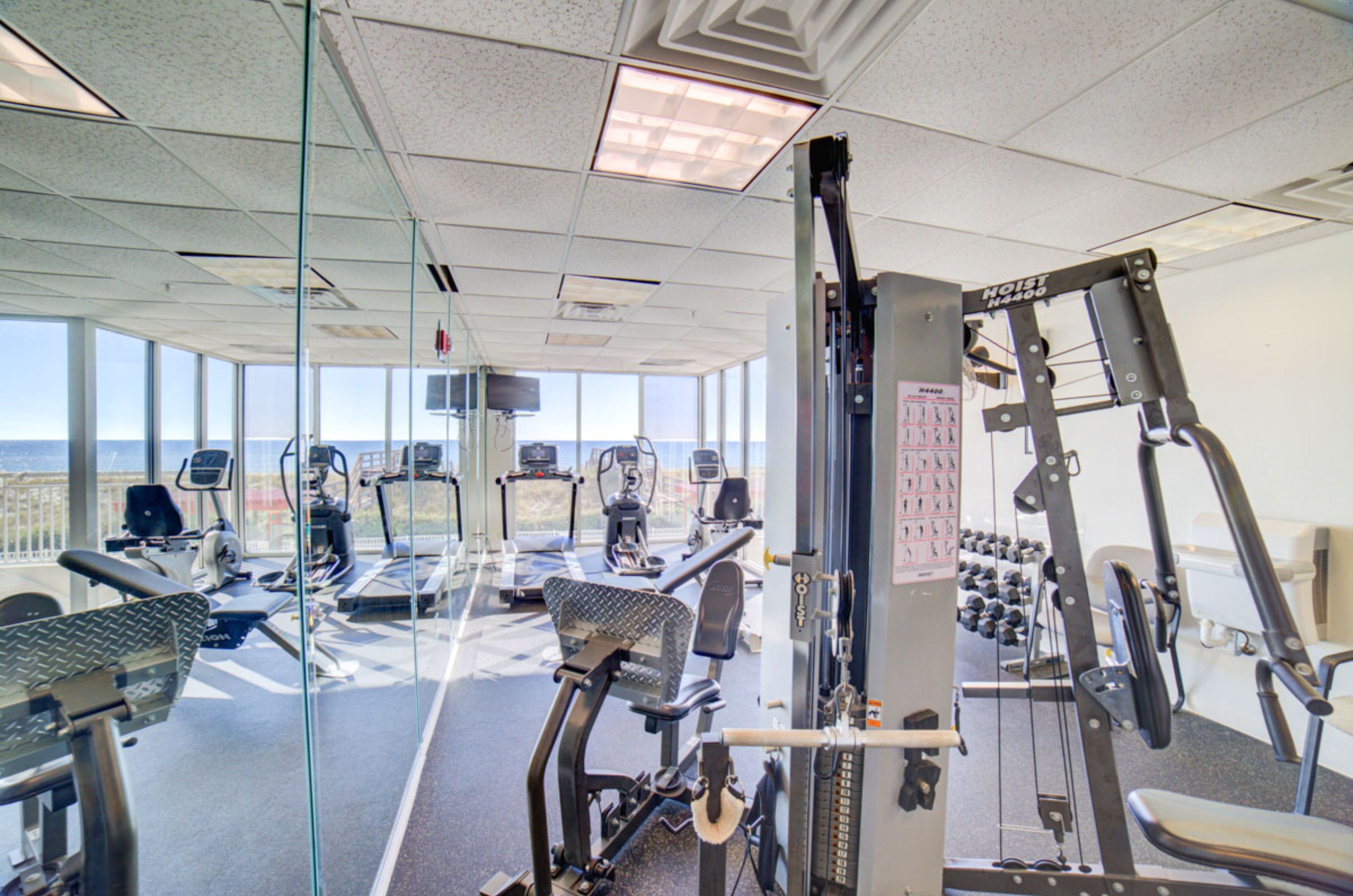 Strength and cardio equipment in a fitness center overlooking the Gulf of Mexico